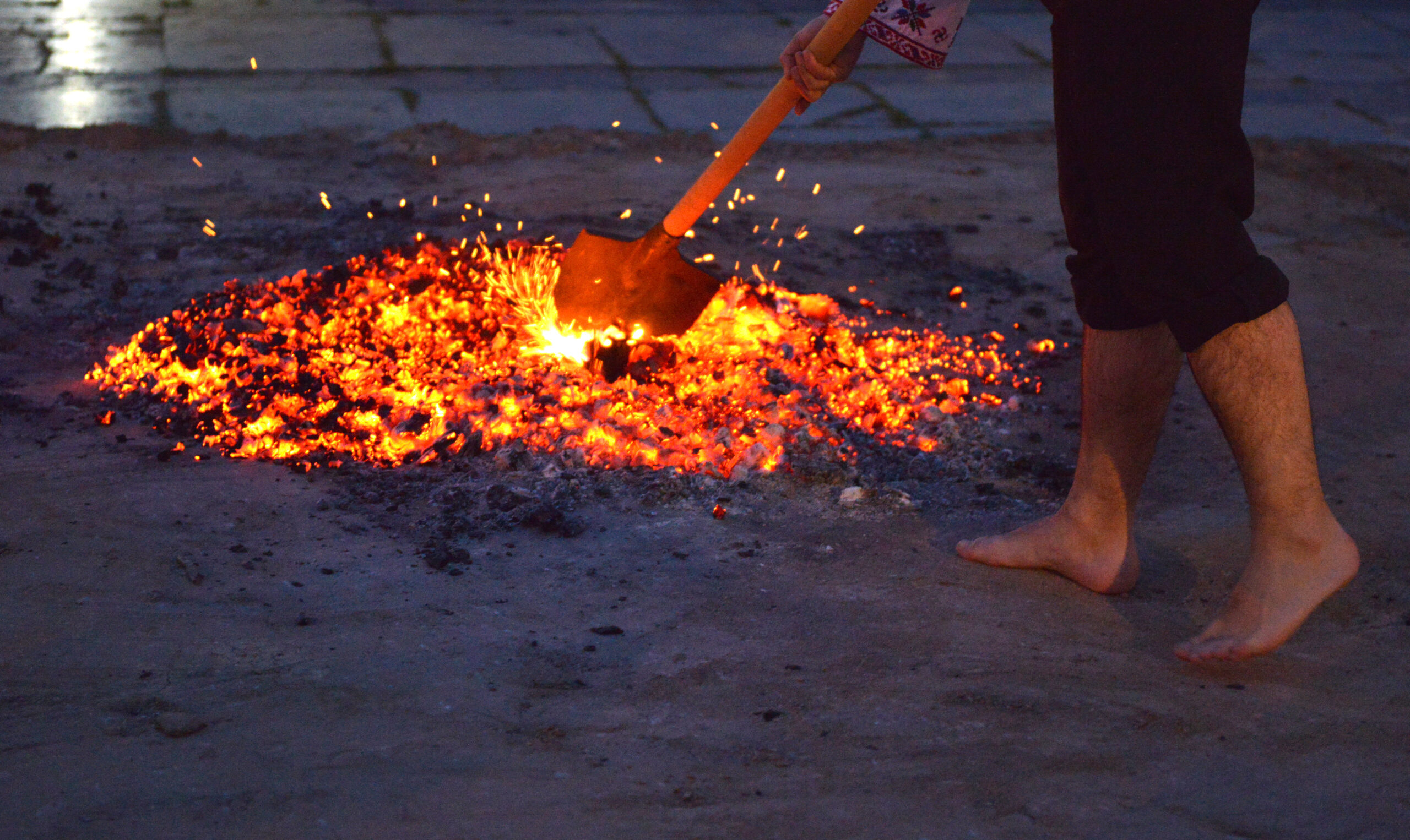 shovel in burning coals preparing fire walk